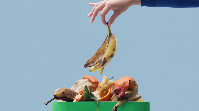 Woman tossing banana peel in compost heap