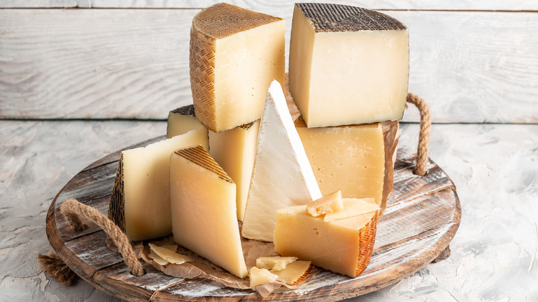 A variety of cheeses on a wooden tray