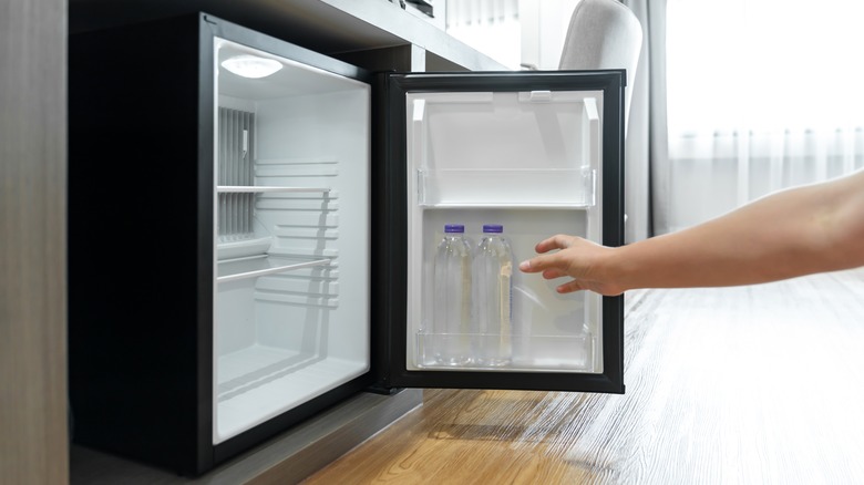 Person reaching into mini fridge