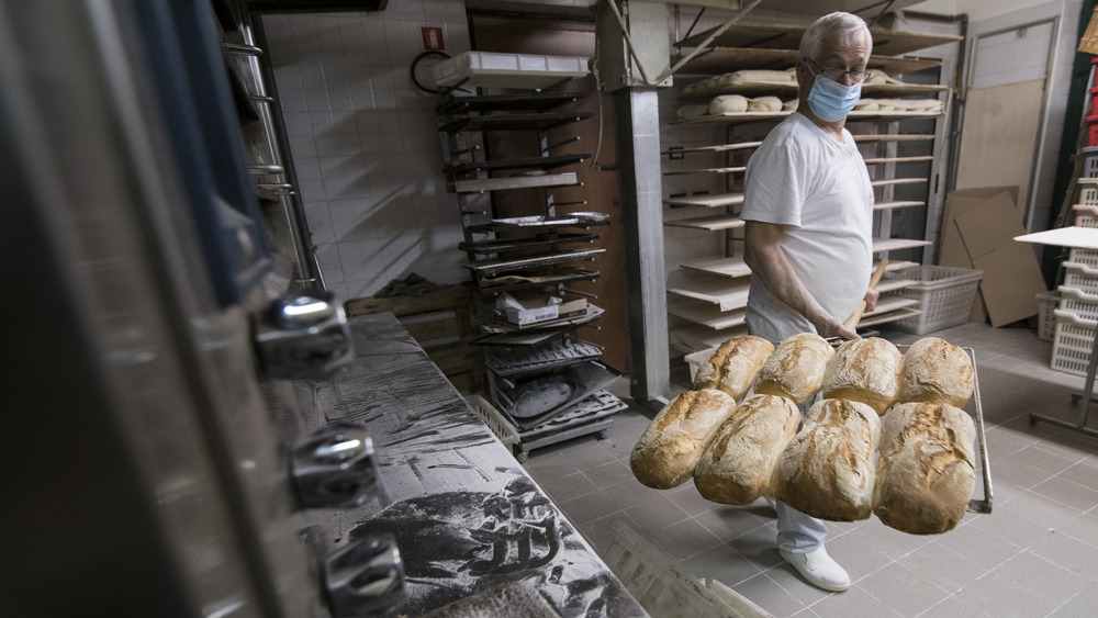 Baker showing off loaves taken from the oven