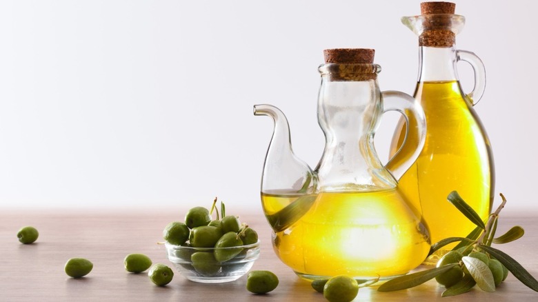 Olives and glass bottles containing olive oil 