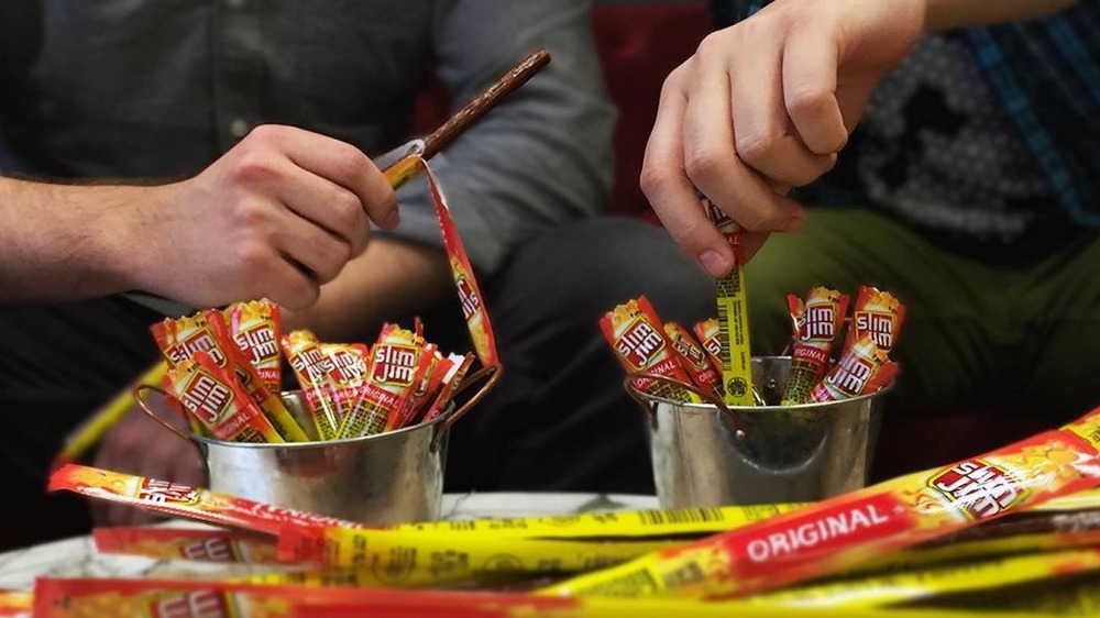 Two men eating Slim Jim