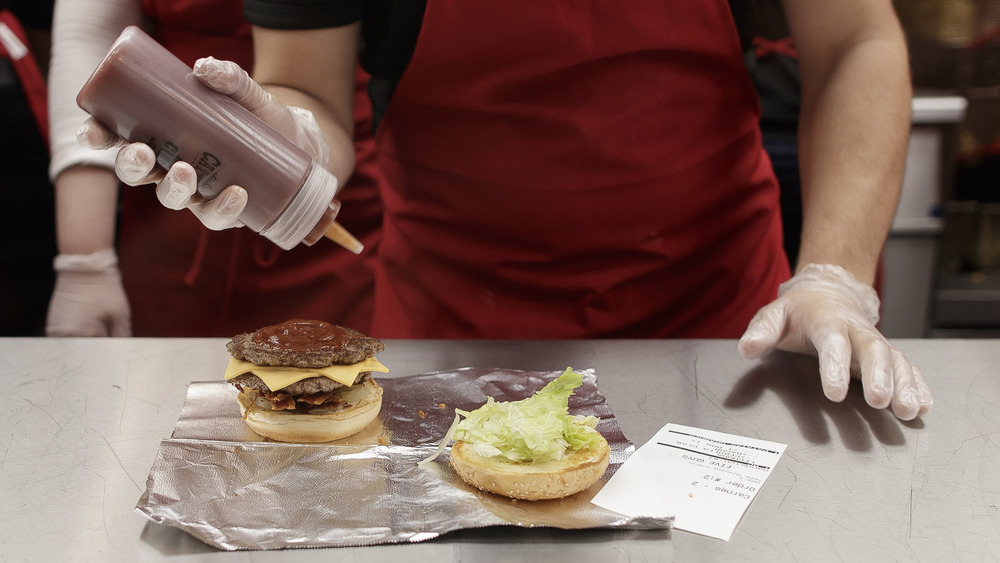 Employee making Five Guys burger