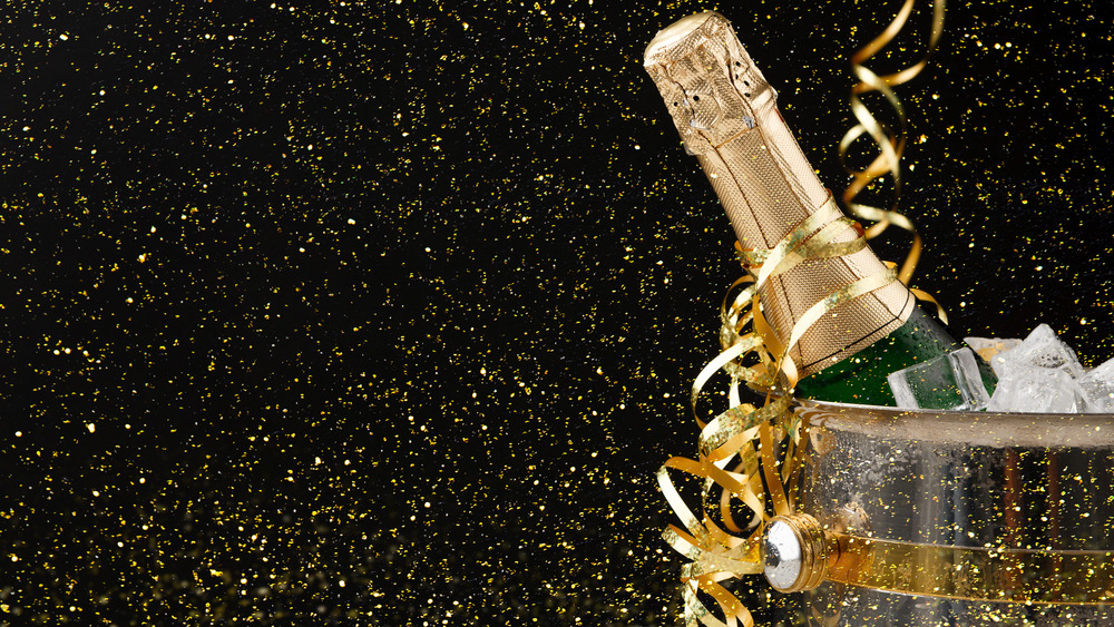 bottle of champagne in an ice bucket with glittery background