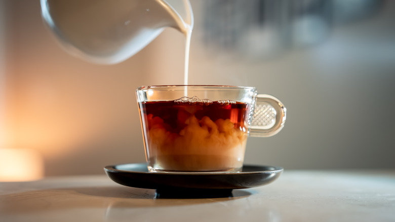 close up of milk being poured into tea