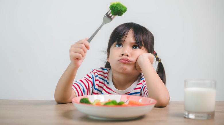   Seorang anak melihat brokoli dengan jijik