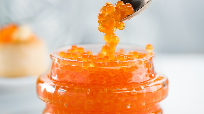 Red caviar spooned out of jar