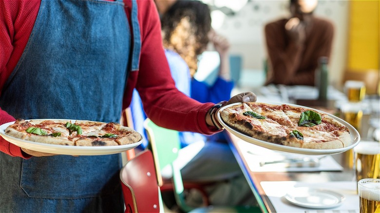 Man serves pizza