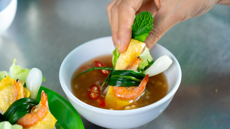 Vietnamese style dipping sauce with vegetables being dipped