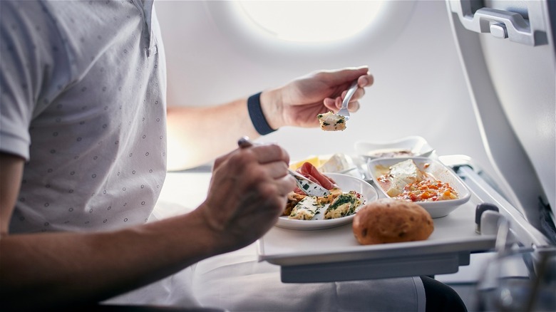 Man eats airplane meal