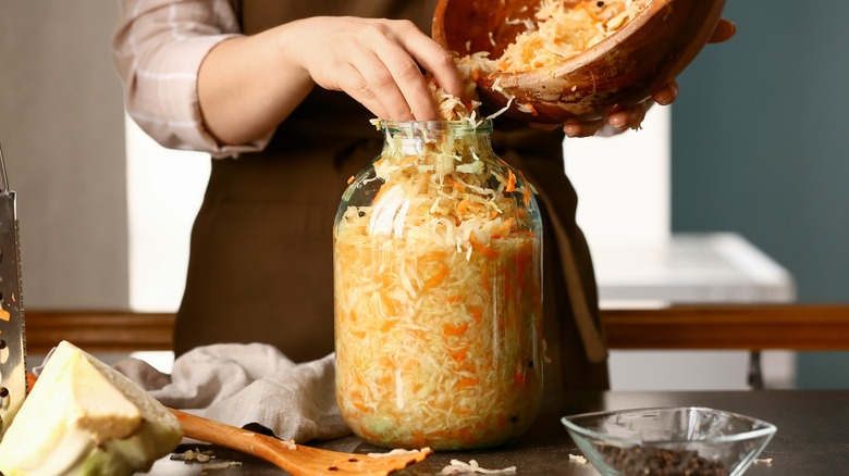 Lady filling a sauerkraut jar