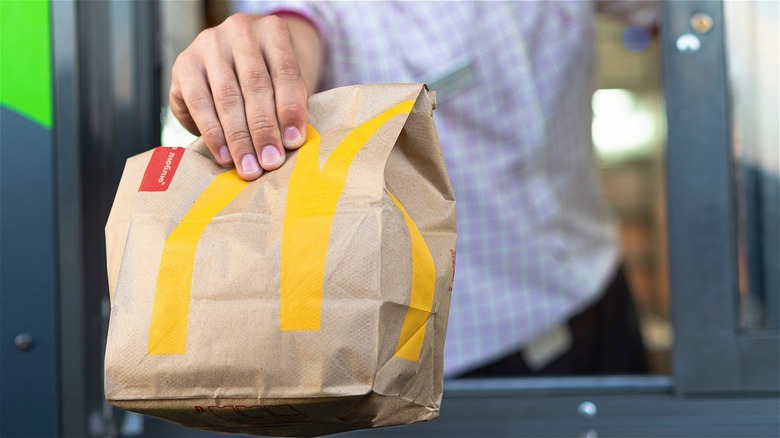Worker handing bag over in McDonald's drive-thru