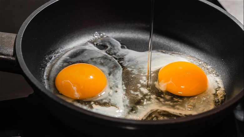 fried eggs cooking in a nonstick skillet