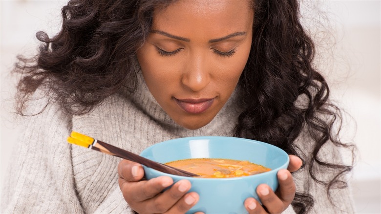 woman holding warm bowl of ramen