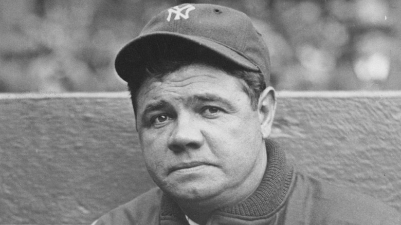 Black and white photo of Babe Ruth wearing a Yankees baseball cap