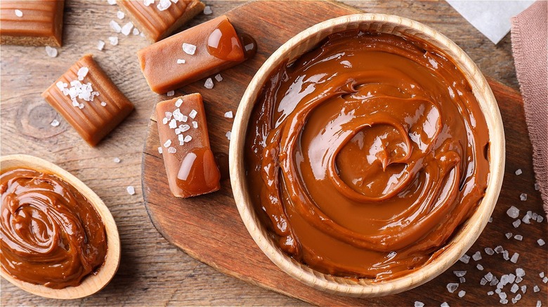 Several variations of sea salted caramel on a wooden cutting board.