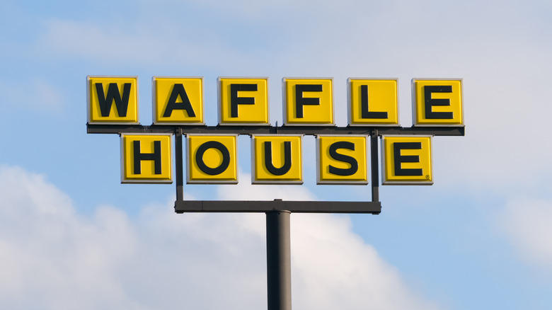 Waffle House sign against blue sky and clouds