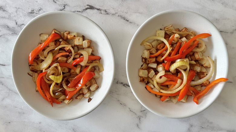potatoes, peppers, and onions in two white bowls