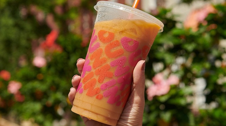 Hand holding Dunkin Donuts coffee