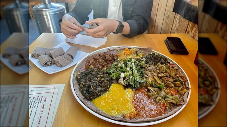 Diner sitting in front of a plate of Ethiopian food