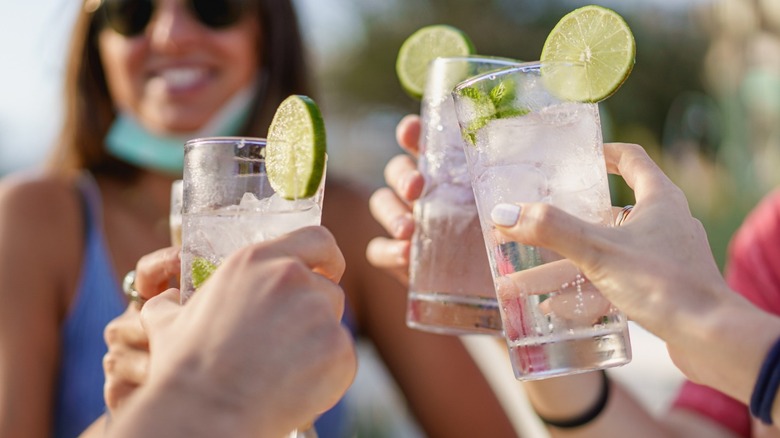 Women cheers with clear drinks