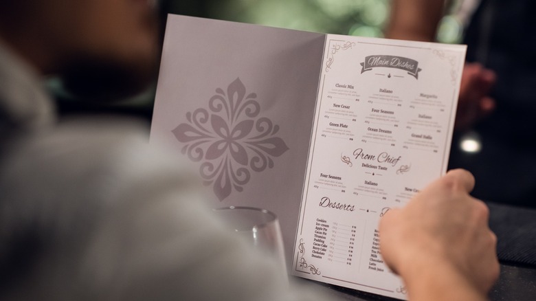 Hands holding a menu