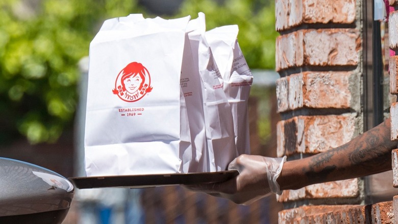 Wendy's employee handing over order in drive-thru