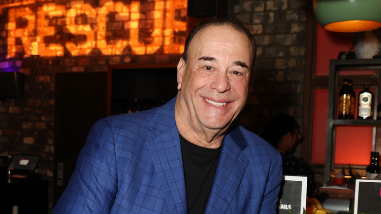 Jon Taffer smiling in blue suit in front of 