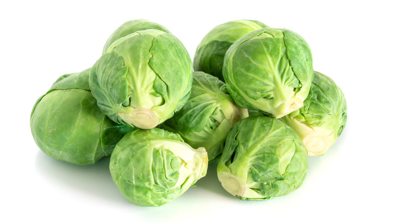 A small stack of Brussels sprouts against a white background 