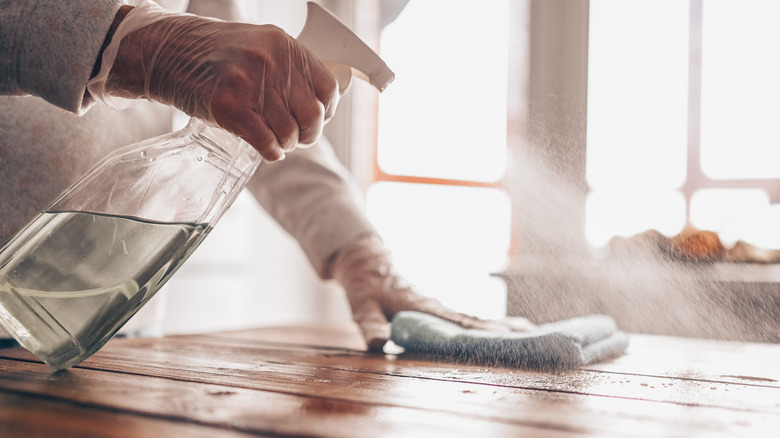Person spraying sanitizer