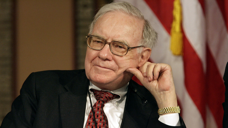 Warren Buffett sitting in front of flag