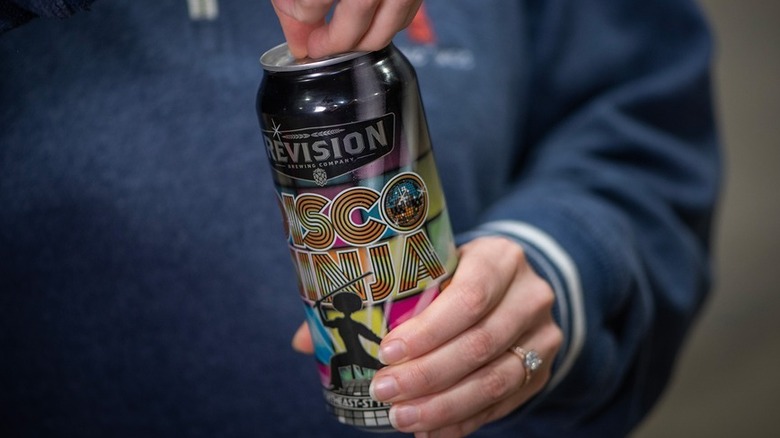 hands opening a Disco Ninja can