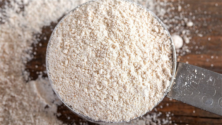 1/4 cup of flour sitting on a table dusted with flour