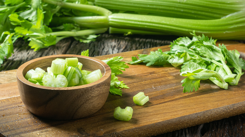 Chopped celery in bowl on cutting board