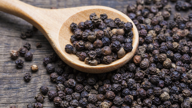 black peppercorns in a spoon