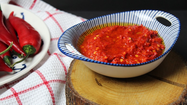 bowl of harissa next to red chili peppers