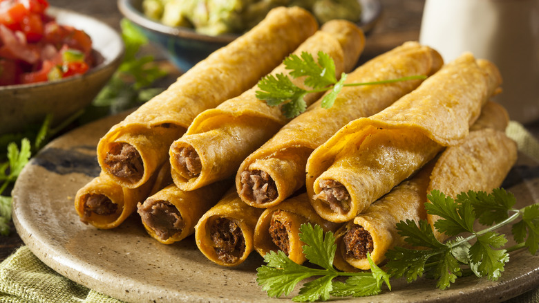 Taquitos stacked on plate