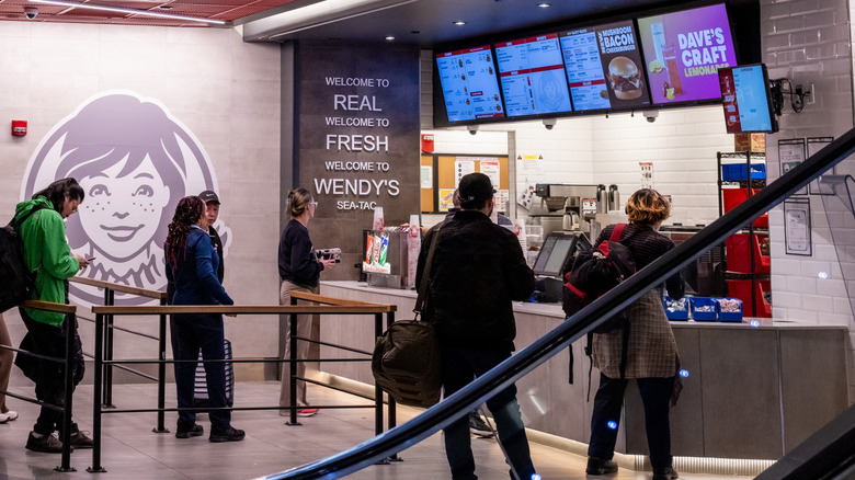 People wait in line at a Wendy's