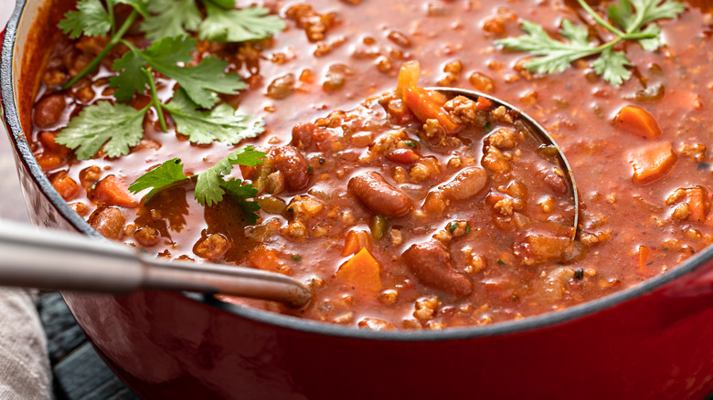 metal ladle dipped into red bean chili