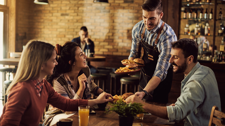 Server with patrons in restaurant