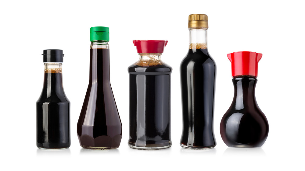 Five unlabeled bottles of soy sauce