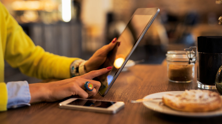 person holding tablet over meal