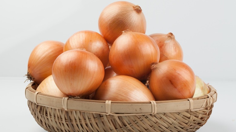 Basket of whole yellow onions. 