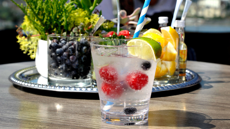 Glass of seltzer with fruit and straw