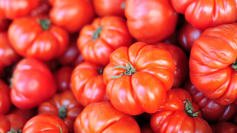 Pile of beefsteak tomatoes in grocery store.