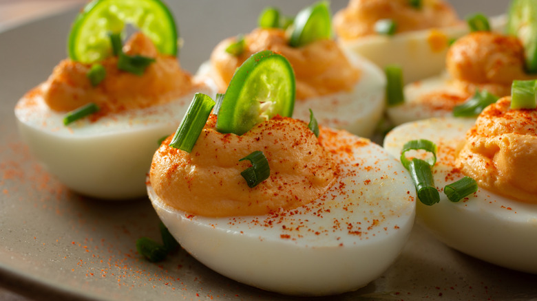 Deviled eggs with jalapeño slices in filling