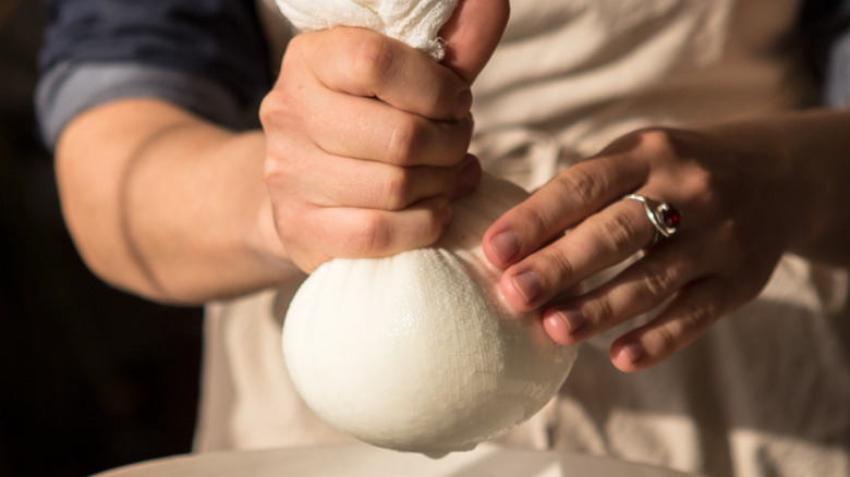 Straining milk with cheesecloth