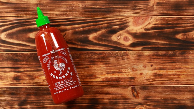 bottle of sriracha on wooden background