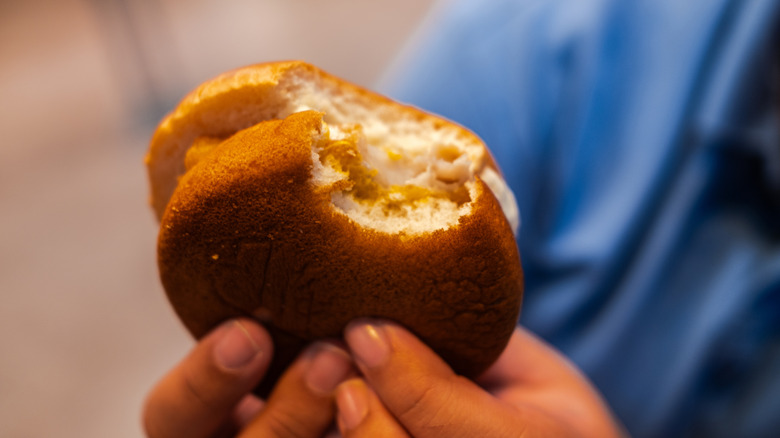 person holding Filet-o-Fish sandwich with bite taken out