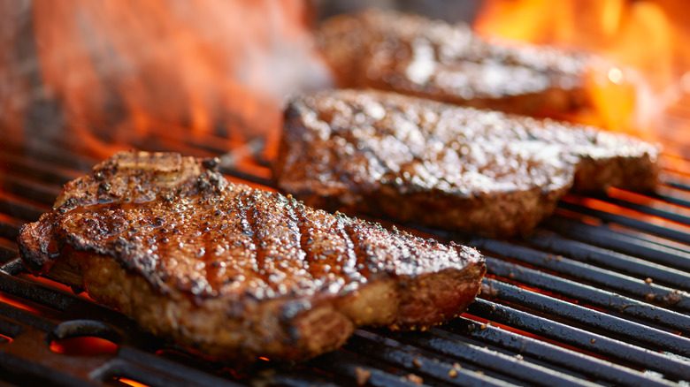 Steaks on grill with flames